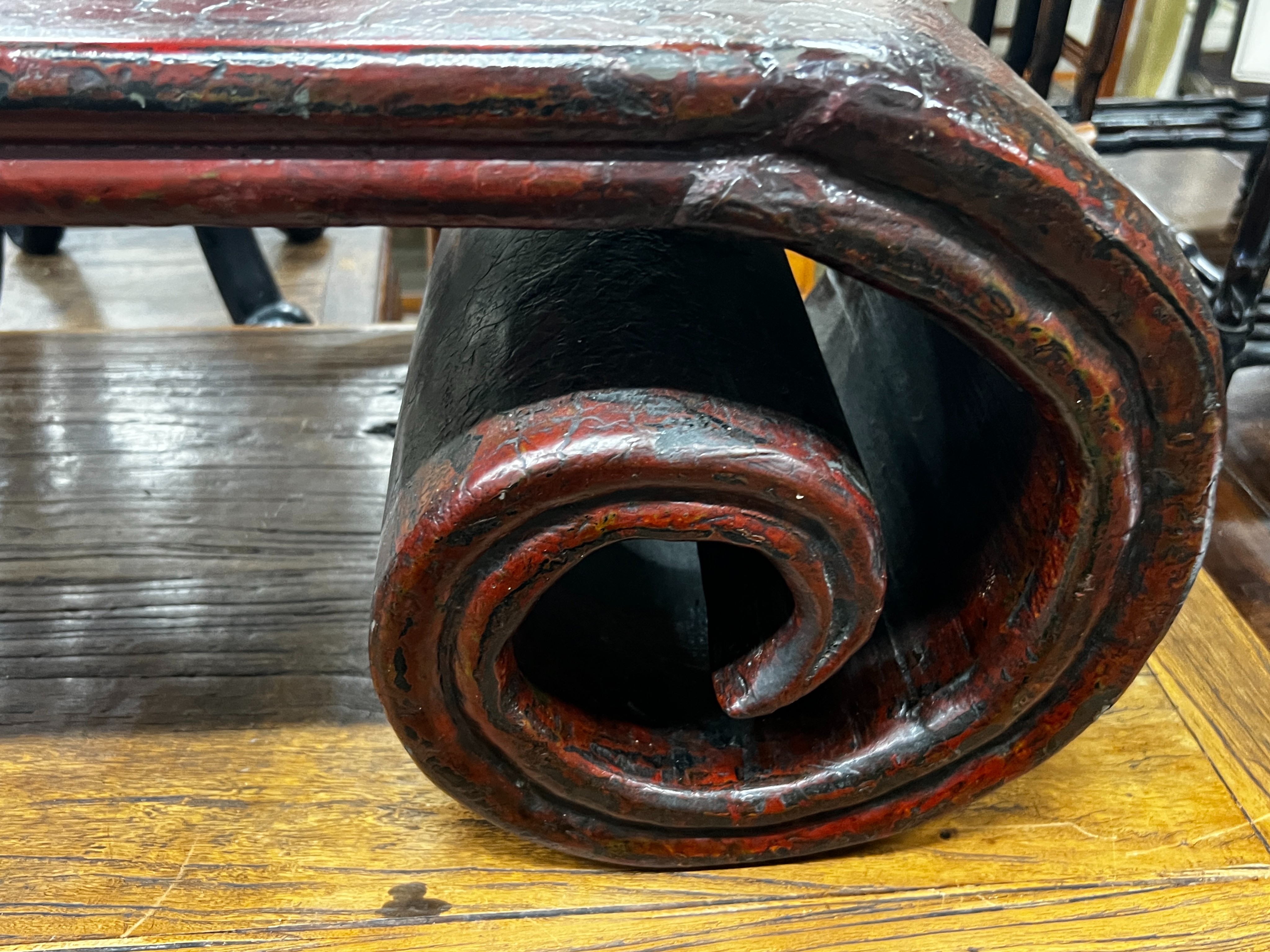 A Chinese lacquer scroll end low table, width 146cm, depth 35cm, height 33cm